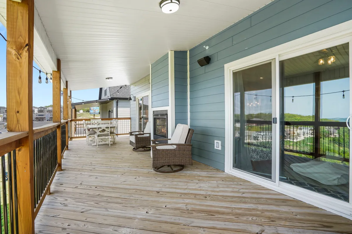 A private wooden deck extends from the cottage, furnished with comfortable outdoor seating and offering a cozy fireplace. The deck overlooks scenic natural surroundings and is designed for relaxing, entertaining, or simply soaking in the view.